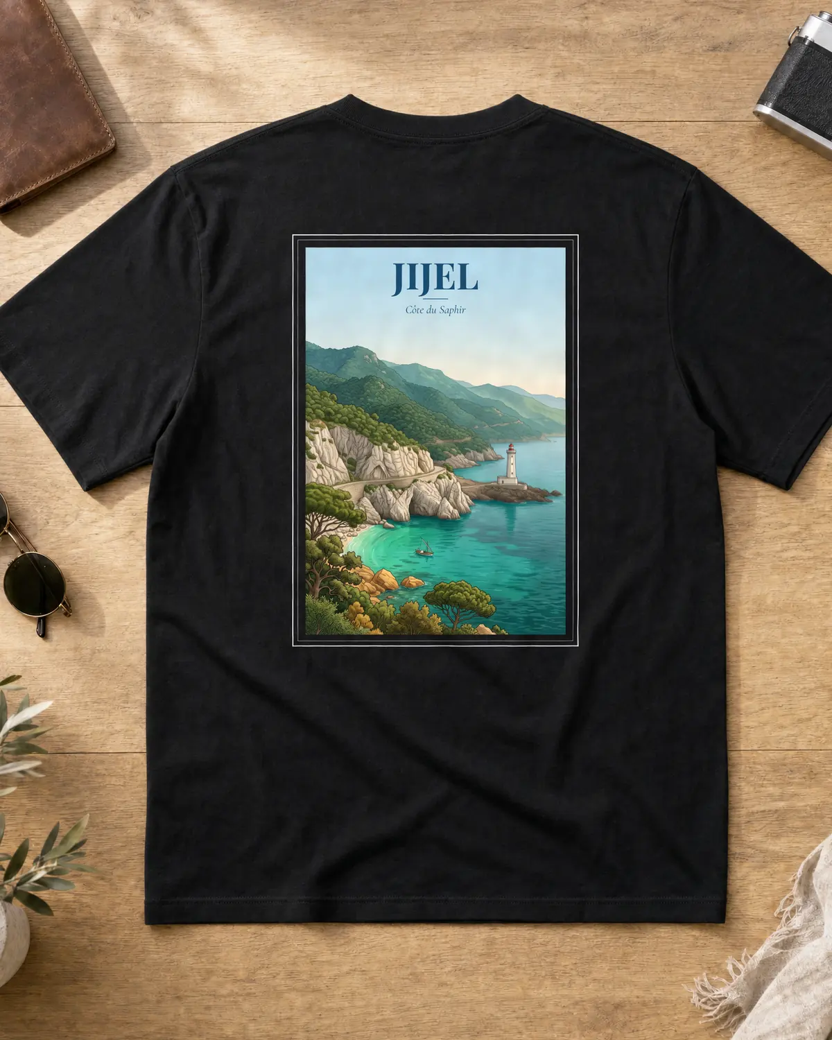 Black Jijel t-shirt back with a vintage travel poster of the turquoise Corniche Jijelienne, a lighthouse and pine cliffs